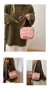 Detail showing pink canvas crossbody bag with white dog print and a small cute charm