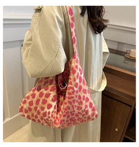 Detail of pink and beige leopard print canvas tote bag with wide shoulder strap