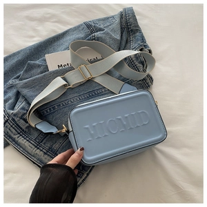 Detail der hellblauen Box-Tasche mit MICMID-Reliefbuchstaben und breitem Stoffgurt