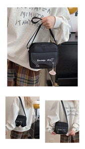 Detail of black crossbody bag with sausage dog print and cute piglet charm accessory