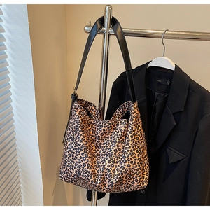 Détail du sac cabas en daim léopard avec bandoulière réglable en cuir noir chic