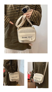 Detail view of cream canvas crossbody bag with sausage dog print and plush charm