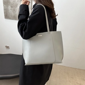 Minimalist light gray faux leather tote bag with elegant metal accent and long shoulder straps
