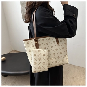 Detail view of large white tote bag with pattern and matching small pouch charm