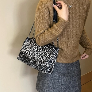 Sac à bandoulière chic à motif léopard avec chaîne argentée porté par un mannequin
