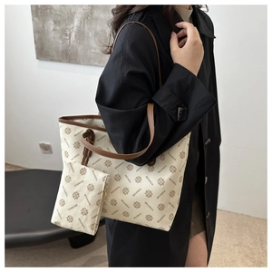 Detail of large tote bag in off-white monogram leather with brown trim and small pouch