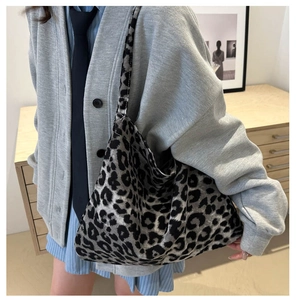 Detail of a large leopard print canvas tote bag carried over the shoulder for fashion