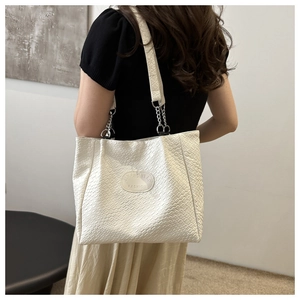 Detail view of the white quilted woven pattern tote bag with silver chain straps