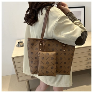Detail of a large brown tote bag with retro floral pattern shown on a shoulder