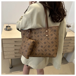 Detail view of large brown tote bag with matching zipper pouch and printed logo pattern