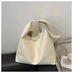 Detailed texture of the creamy white pleated leather tote bag in an indoor setting