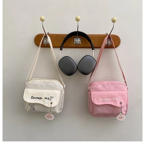 Detail of canvas crossbody bags with cute sausage dog prints and matching pendants