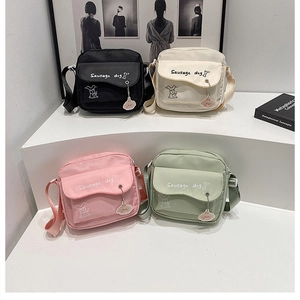 Detail of four colorful canvas crossbody bags with sausage dog print on display stand