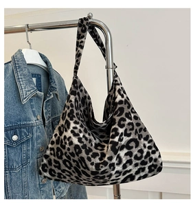 Detail of leopard print tote bag in grey and black fabric hanging on a metal rack