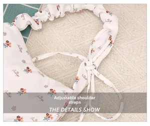 Detail showing adjustable drawstring shoulder strap on floral print crescent underarm bag
