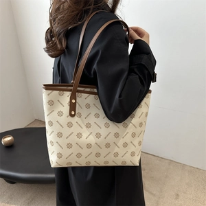 Large capacity canvas tote bag with brown leather trim and geometric monogram pattern