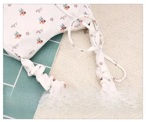 Detailed shot of the ruffled shoulder strap on the white floral crescent hobo bag