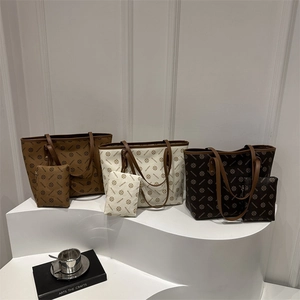 Three-color vintage monogram tote bag set with matching pouch on minimalist display