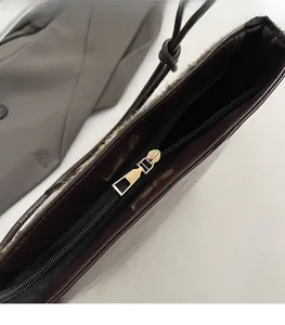 Gros plan sur la fermeture éclair dorée lisse du grand sac cabas bordeaux