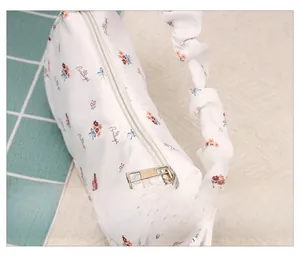 Detail of floral print canvas bag with smooth silver zipper and ruched scrunchie strap