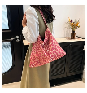 Close-up of pink leopard print tote bag with vibrant orange pattern and canvas texture