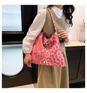 Pink leopard print tote bag styled as a large shoulder bag for women on beige outfit