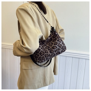 Vue détaillée d'une femme portant un sac à bandoulière léopard tendance avec chaîne dorée