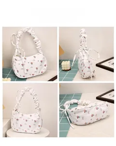 Detail view of white floral shoulder bag with ruffled handle and bow decoration