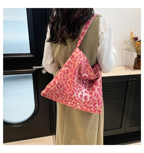 Rear view of a model wearing the pink leopard print tote bag as a shoulder bag