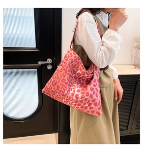 Detail of trendy leopard print tote bag with heart pattern and wide shoulder strap