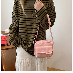 Detail of pink crossbody bag with sausage dog print and adjustable nylon strap