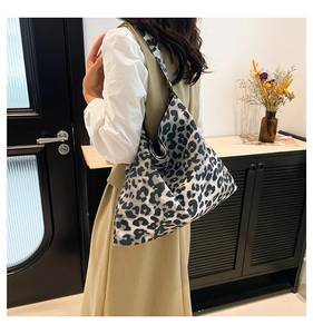 Detailed view of the leopard print pattern and fabric texture on a large hobo tote bag
