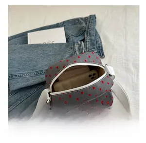 Vue détaillée du compartiment intérieur spacieux du sac bandoulière en toile à pois