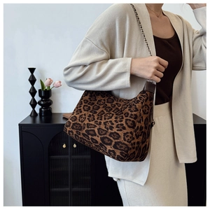 Détail du sac hobo imprimé léopard avec bandoulière en chaîne dorée et texture animale