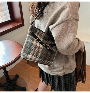 Détail du sac seau en tweed à carreaux vintage avec lanières en cuir et boucles dorées