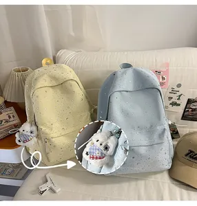 Close-up of star pattern canvas backpacks with cute plush puppy keychain detail