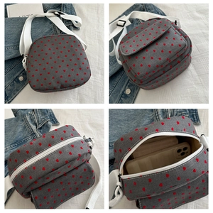 Détails du sac bandoulière en toile grise avec motif de cœur rouge et sangle réglable