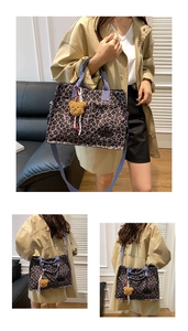 Detail of purple leopard print tote bag with blue handles and brown plush bear charm