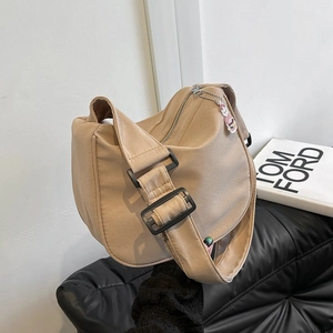Détail du sac bandoulière en toile avec fermeture éclair et pendentif peluche rose