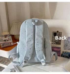 Close-up of light blue star-patterned backpack back with adjustable straps and zipper pocket