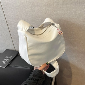 Détail du sac demi-lune en toile blanche avec accessoire créatif en forme de hamburger