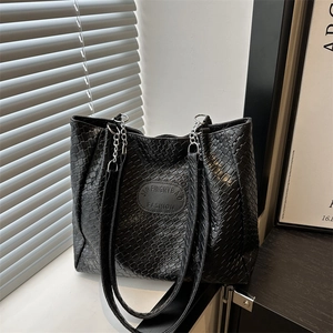 Minimalist black woven tote bag with quilted diamond pattern and metallic chain straps