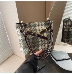 Détail d'un sac cabas en tweed à carreaux avec poignées en cuir et ferrures dorées chic