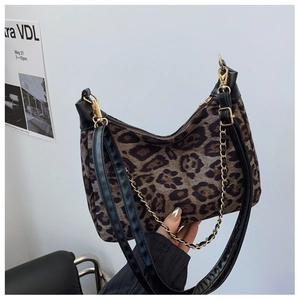 Détail d'un sac bandoulière léopard avec chaîne dorée et bandoulière en cuir noir
