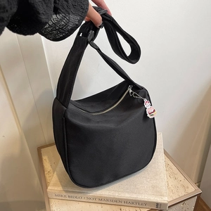 Sac bandoulière noir minimaliste en forme de croissant avec breloque burger