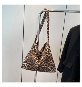 Detail shot of wide shoulder strap on leopard print tote bag with soft fabric texture