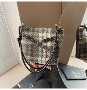 Détail du sac bandoulière en tweed à carreaux verts avec poignée en cuir noué et doré poli
