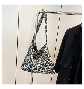 Macro shot of large leopard print tote bag in smooth black and grey satin fabric texture