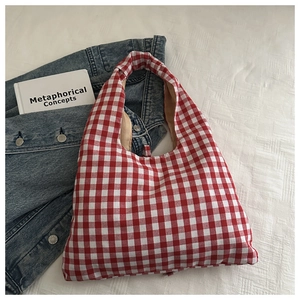Detail shot of a red and white checkered tote bag with a high-quality fabric texture