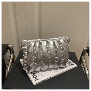 Detail of silver metallic cloud bag with quilted pleats on a stylish magazine